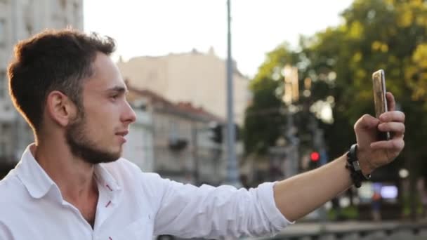 Macho atraente em seus 20 anos tirando foto panorâmica usando seu smartphone ao ar livre — Vídeo de Stock