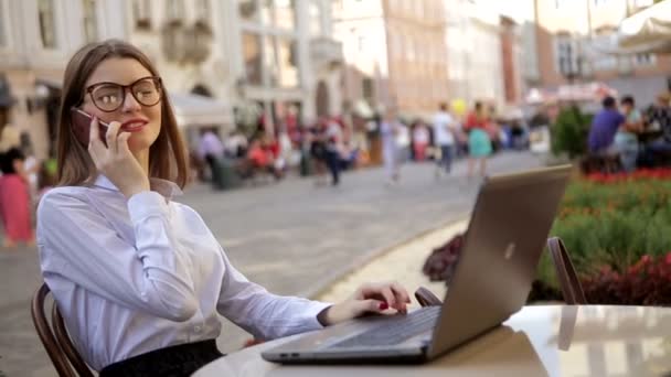 Ler attraktiv dam med röda läppar är talar i hennes mobiltelefon och använder sin laptop — Stockvideo