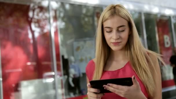 Fiatal hölgy koncentrált közleményben a barátjával, digitális tabletta, az utcán keresztül — Stock videók