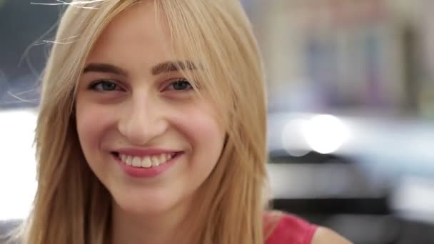 Joven mujer sonriendo mientras su pelo sopla en el viento — Vídeos de Stock