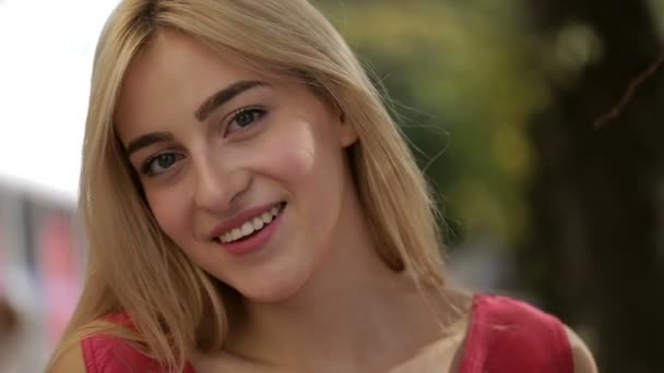 Young woman smiling while her hair blows in the wind — Stock Video