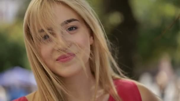 Joven mujer sonriendo mientras su pelo sopla en el viento — Vídeos de Stock