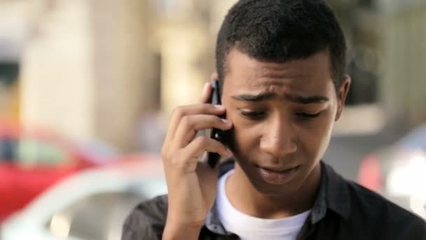 Un adolescente muy joven está hablando seriamente a través del teléfono móvil — Vídeo de stock