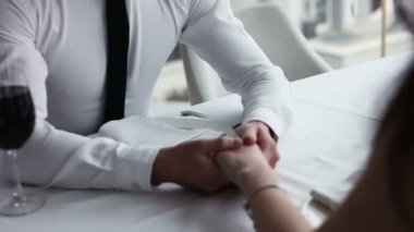 Ceketli adam genç kadının elini alır ve restoranda oturup konuşurken konuşmak