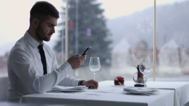 cep telefonuyla restoranda yakışıklı adam