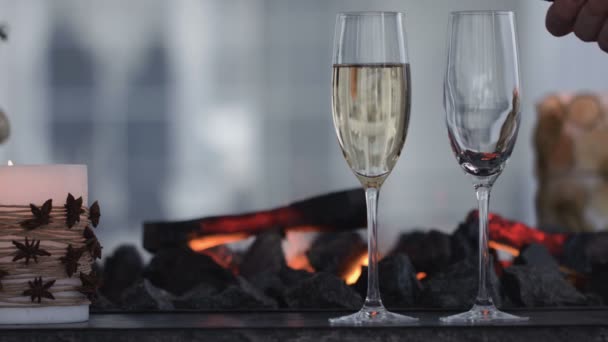 Sparkling champagne wine in glasses in front of the warm fireplace. Close up — Stock Video