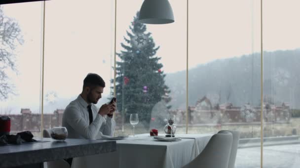 Красивий чоловік з мобільним телефоном в ресторані — стокове відео
