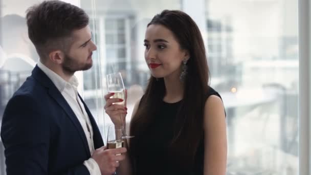 Restaurante, pareja y concepto de vacaciones - pareja sonriente con una copa de champán mirándose en el restaurante — Vídeos de Stock