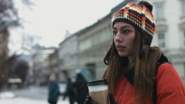 Genç erkek açık havada paket servisi olan restoran kahve içme ve birini bekliyor. Çekici kadın biri için kalabalıktan arıyor.