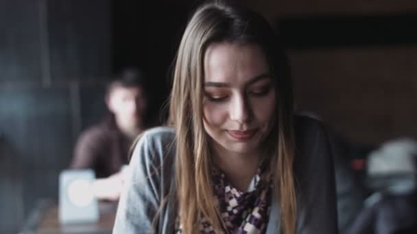 Primer plano de la joven mujer caucásica sentada en el café europeo y hablando con un hombre . — Vídeo de stock