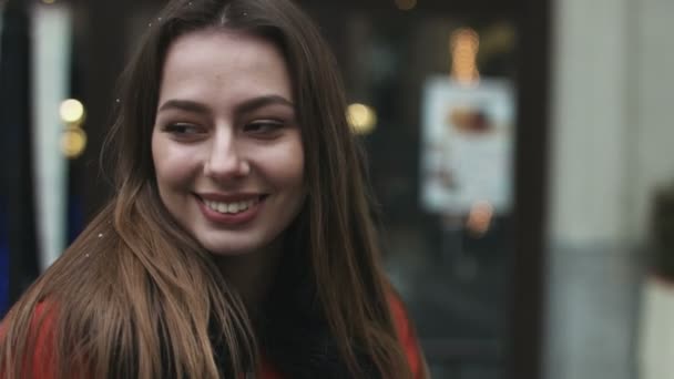 Close-up de uma bela jovem mulher assistindo direto para a câmera ao ar livre . — Vídeo de Stock