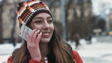 Yakın çekim portre tatlı bir konuşma telefonda sahip genç bir kadın.