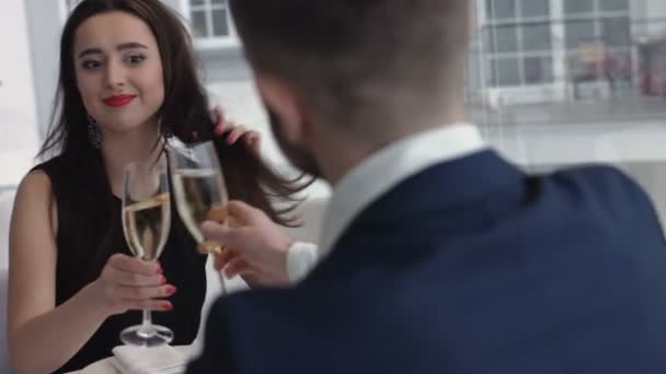 Casal bem vestido torrando flautas de champanhe no restaurante — Vídeo de Stock
