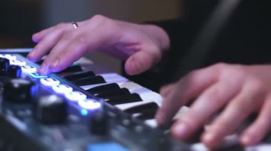 Elektronik klavye ve acil yastıkları bir denetim masasında oynarken müzik sanatçılarının yakın çekim resim eller.