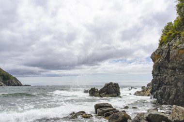 Dalgalar kayalarda kırılıyor .