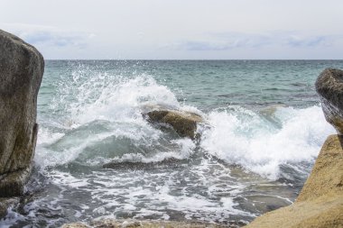 Dalgalar kayalarda kırılıyor .