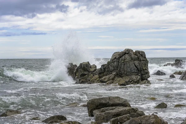 Dalgalar kayalarda kırılıyor .