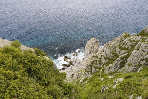 Dalgalar kayalarda kırılıyor .