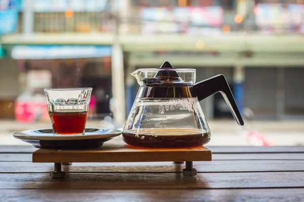 drip coffee cup and coffee pot on wood table in coffee shop.