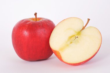 Beyaz arka plan üzerinde bir buçuk kırmızı elmalar