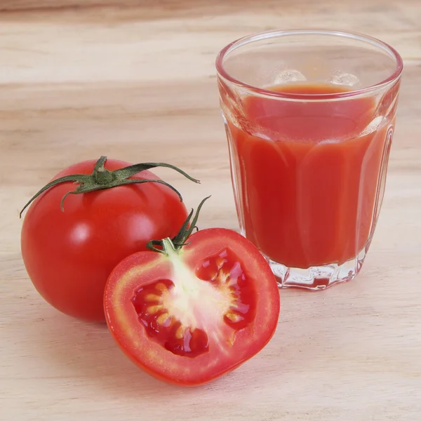 Tomatensaft und Tomatenscheiben auf Holz-Hintergrund — Stockfoto
