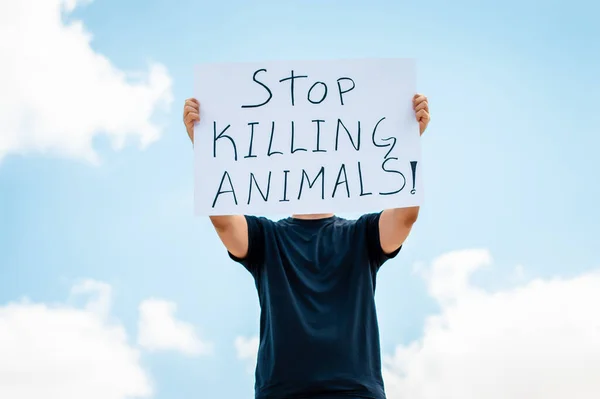 動物を殺すのをやめろというサインを持った男 — ストック写真