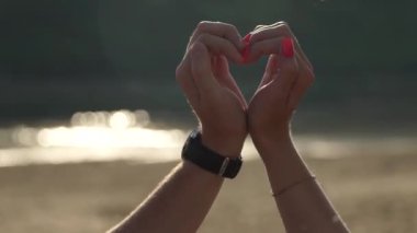Aşıklar kalp işaretini kendi elleriyle gösterir.