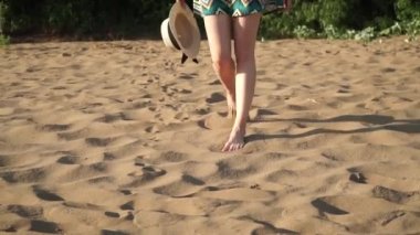 Kumsalda yürüyen kız.