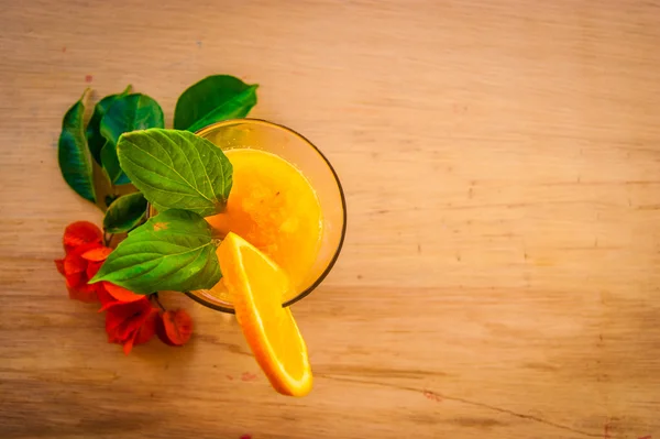 Photo of Orange cocktail smoothie juice with mint and red flower — Stockfoto