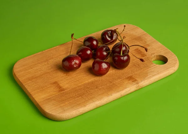 Deliciosas cerezas sober tabla de madera