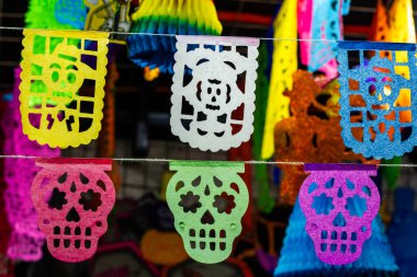 Çizgiden sarkan renkli kağıt kafatasları. Kafatasları farklı renk ve boyutlarda. Meksika Ölüler Günü geleneği, adaklar, yemek, renkler, dekorasyonlar ve papel picado, La Catrina.