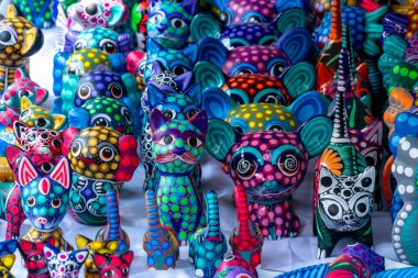 Masada kedi ve köpekleri de içeren renkli bir hayvan heykeli koleksiyonu sergileniyor. Meksika Ölüler Günü geleneği, adaklar, yemek, renkler, dekorasyonlar ve papel picado, La Catrina.