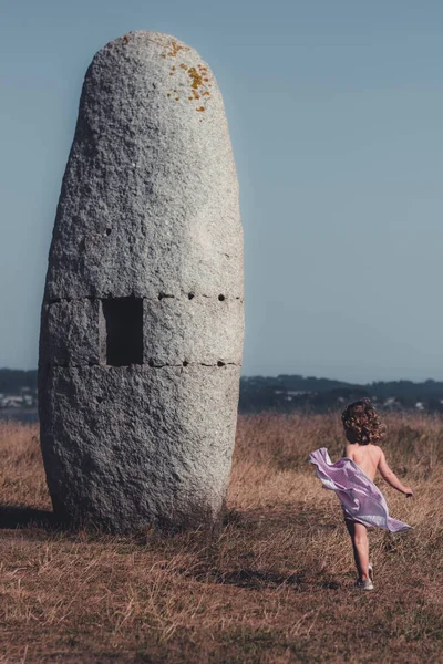 A Corua, İspanya 'da eski bir Menhir' in önünde dans eden küçük kız.