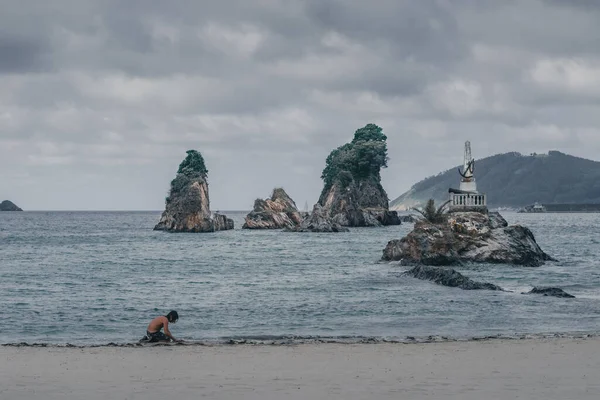 Galiçya, Viveiro plajında kumla oynayan yalnız bir adam..