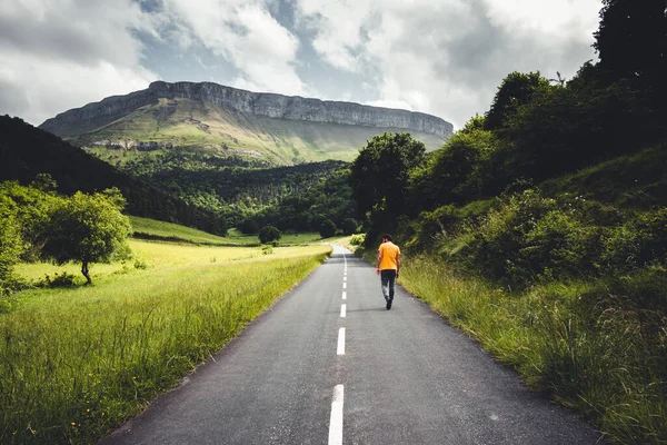 Bask ülkesindeki Aiaraldea Vadisi 'nden büyük bir manzarada bir rampa boyunca yürüyen bir adam..