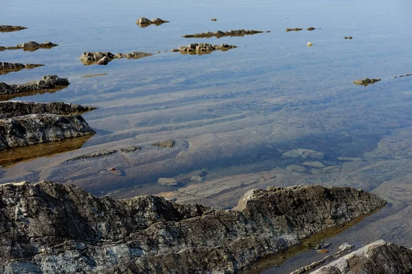 Kayalık bir taban berrak suda görülebilir.