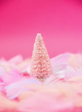 Tüylü kar üzerinde pembe parıltılı Noel ağacı. 