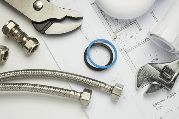 Plumbing tools and parts on house plans — Stock Photo, Image
