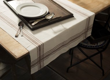Masa örtüsü yazdırılan kahverengi çizgili Dinnerw ile masaya koydu