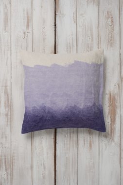 Kare degrade mor yastık atma düz ahşap yüzeyde koydu.