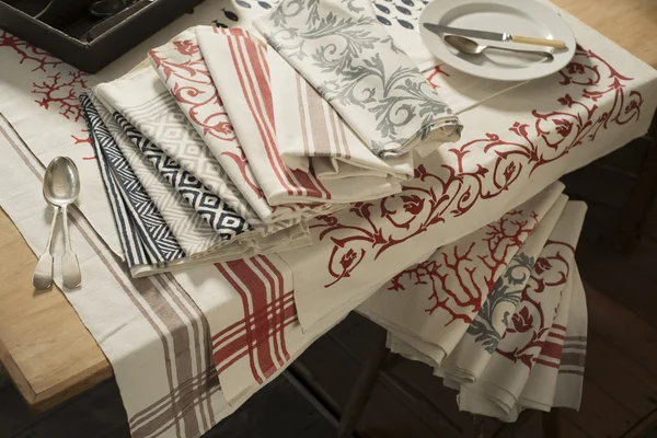 Napkins and Tablecloth of Various Designs on Table and Stool — Stock Photo, Image