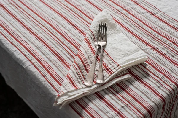 Bovenaanzicht van vorken, servet tafelkleed met rode en bruine strepen — Stockfoto