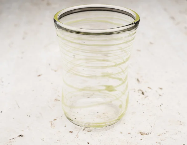 Crystal Drinking Glass with Yellow Green Streaks on Stone Surfac — Stock Photo, Image