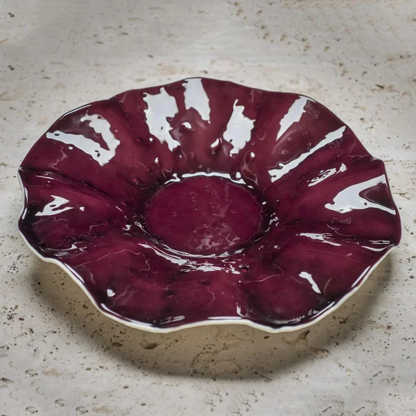 Un tazón de servir en forma de flor granate en la encimera de piedra — Foto de Stock