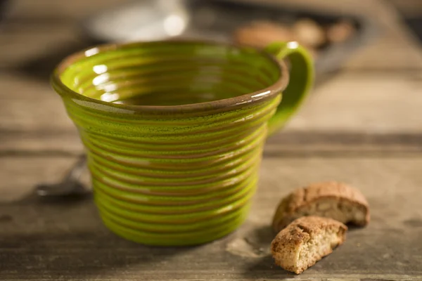 Prázdné zelené šálek mezi lžíci a sušenky — Stock fotografie