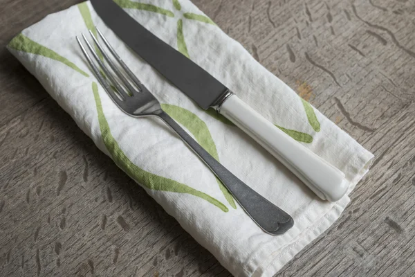 Vork en mes op witte servet met groene concaaf lijnen — Stockfoto