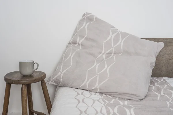 Travesseiro cinzento do lance com linha côncava branca na cama — Fotografia de Stock