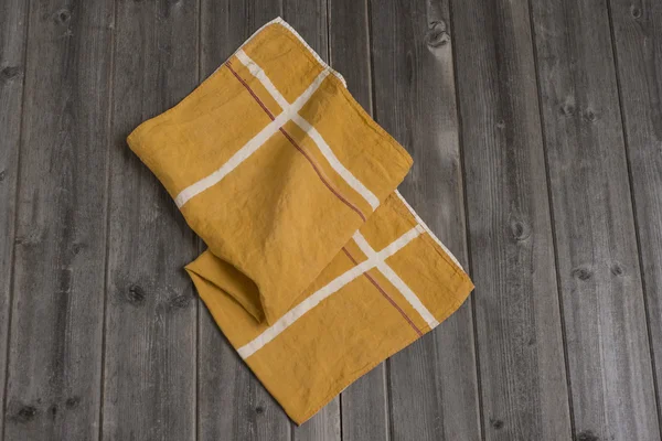 Serviette en tissu jaune avec bandes intersectes blanches et bleu foncé — Photo