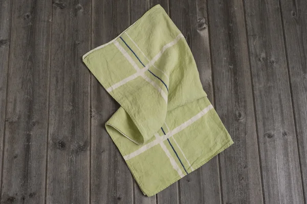Полотенце из зеленой ткани с белыми и темно-синими пересекающимися полосами — стоковое фото