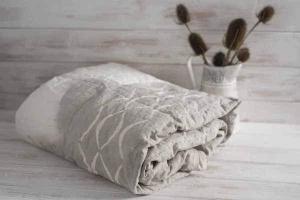 Tweekleurige witte en grijze Dekbedovertrek met Thistle planten opgerold — Stockfoto